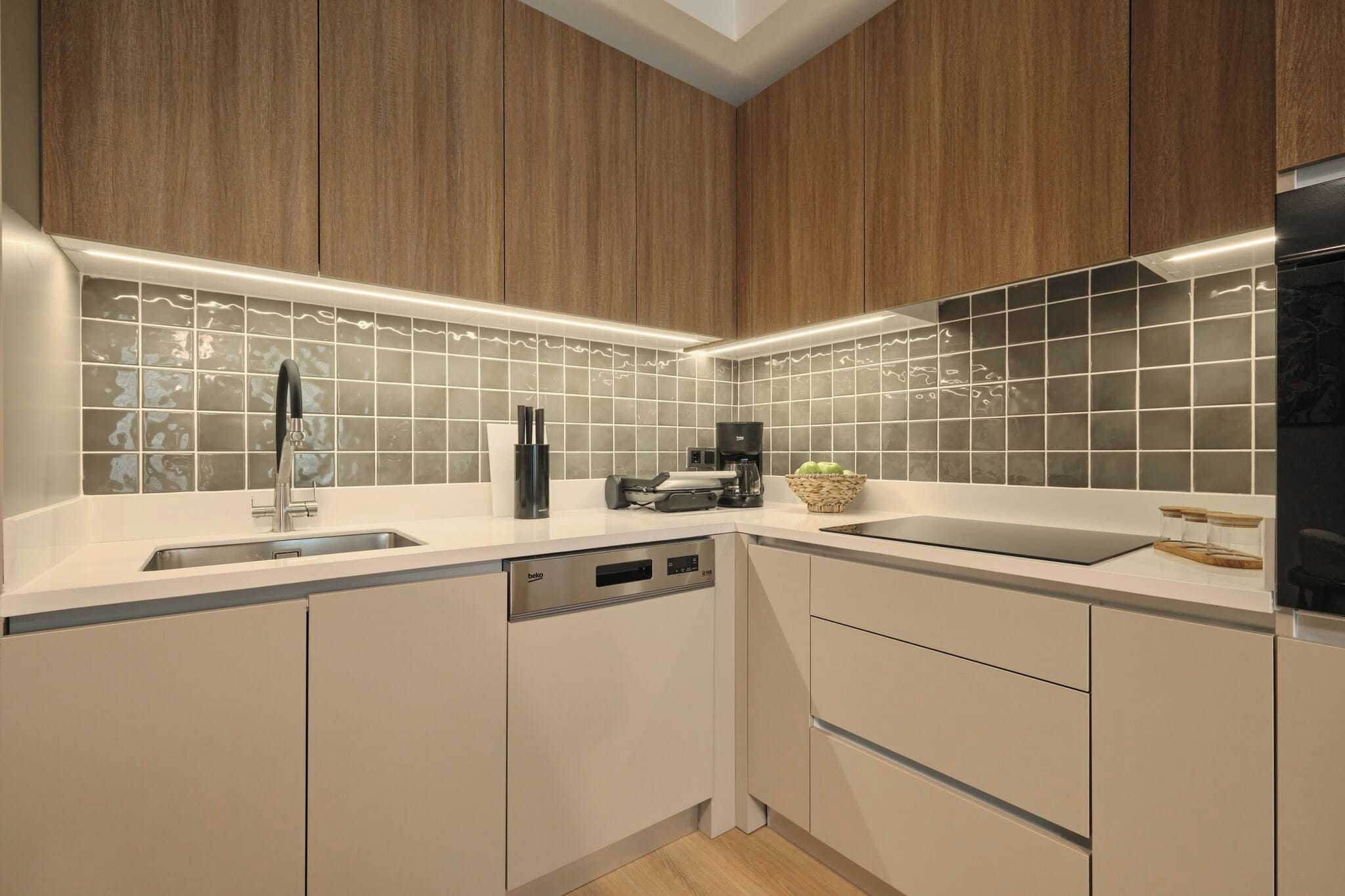 A modern kitchen with wooden cabinets, a dishwasher, a coffee maker, and a sink.
