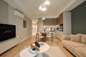 A modern living room with a flat-screen TV, a round coffee table, and a sofa. - Caruana, 2BR, Peaceful, Modern (Kadıköy)