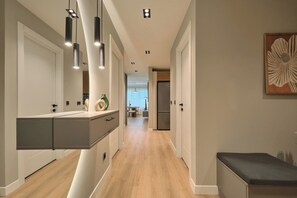A modern hallway with a kitchen area on the left, featuring a built-in bench and pendant lighting. - Spassky, 3BR, Minimalist, Well-equipped (Kadıköy)