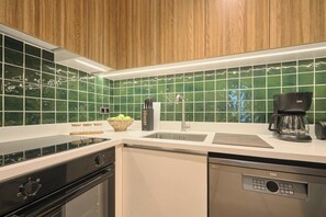 A modern kitchen with a dishwasher, stove, and sink. - Spassky, 3BR, Minimalist, Well-equipped (Kadıköy)