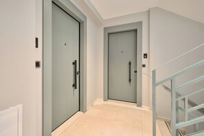 A hallway with two doors, a staircase, and a tiled floor. - Spassky, 3BR, Minimalist, Well-equipped (Kadıköy)