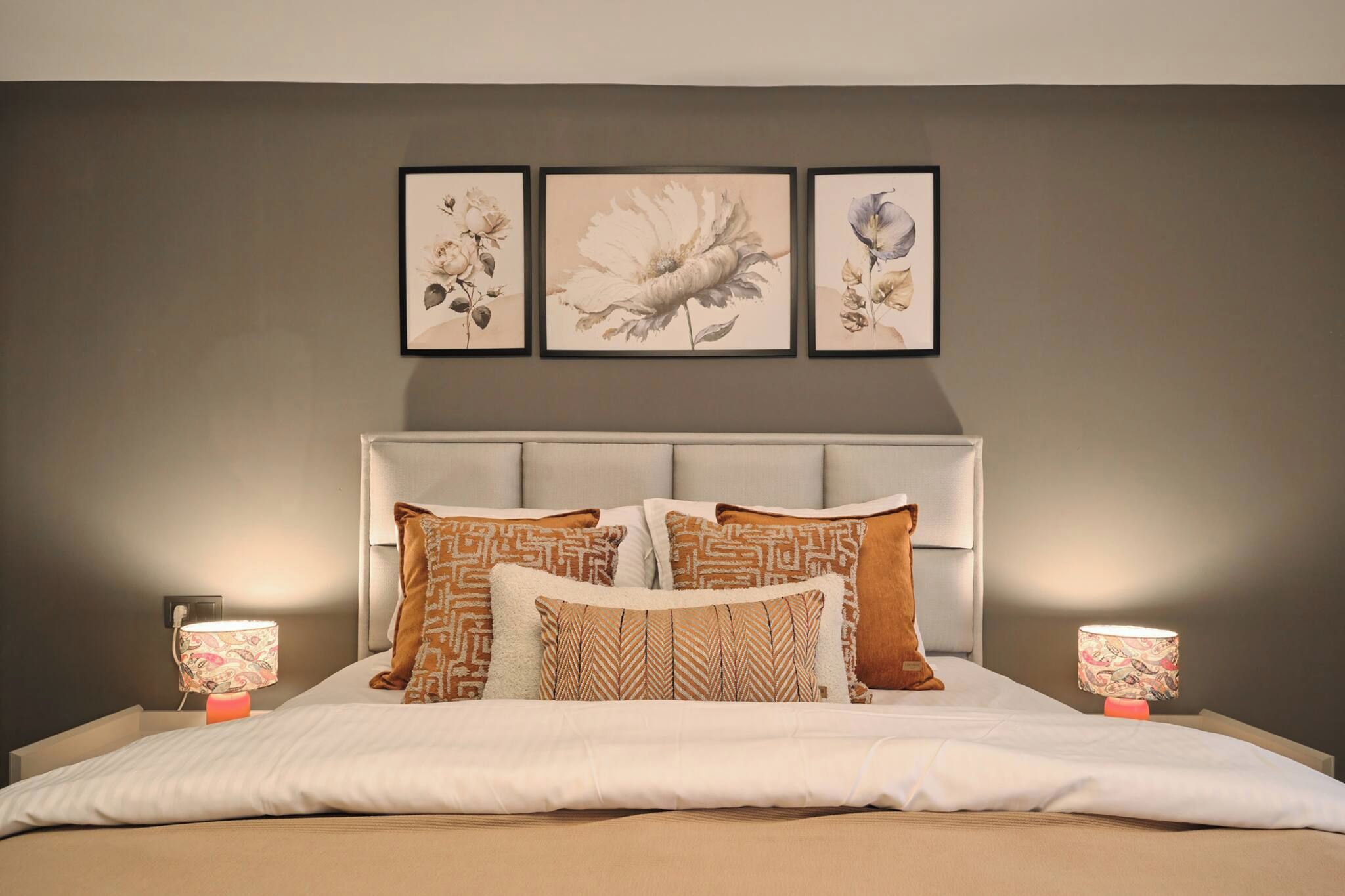 Ein Schlafzimmer mit einem Bett, Kissen und zwei Nachttischlampen.