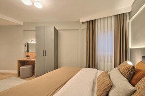 Quarto moderno com uma cama grande, mesa de cabeceira, guarda-roupa e janela com cortinas.