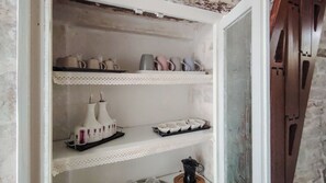Una estantería con diversos objetos de cerámica, como jarrones y tazas.