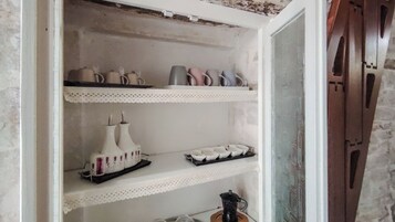 Una estantería con diversos objetos de cerámica, como jarrones y tazas.