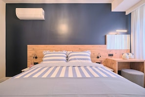 A modern bedroom with a large bed, a wooden headboard, bedside lamps, a nightstand, and a mirror. - Sirius, Modern 2BR, Best Loc (Kadıköy)
