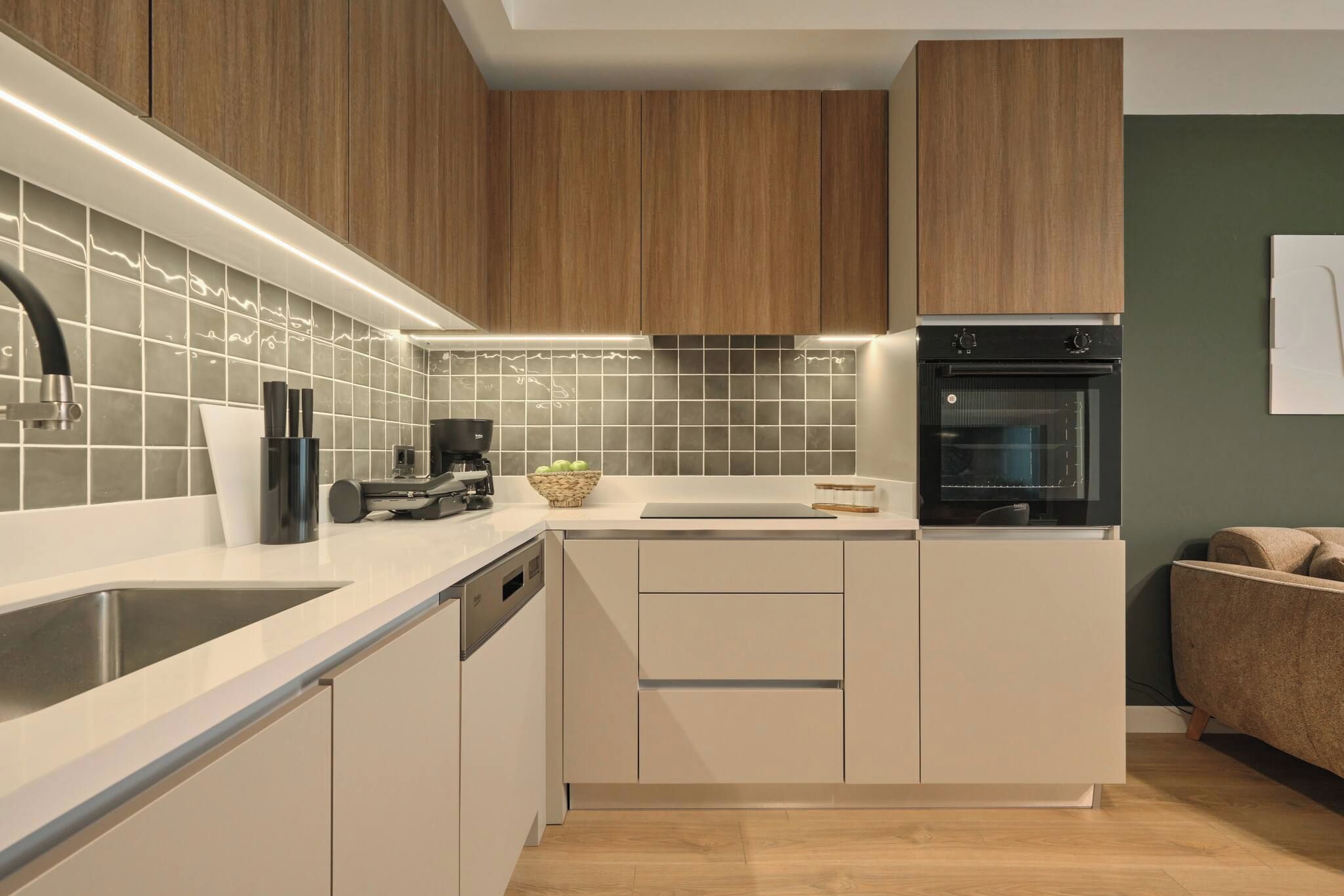 A modern kitchen with a dishwasher, a coffee machine, and a built-in oven.