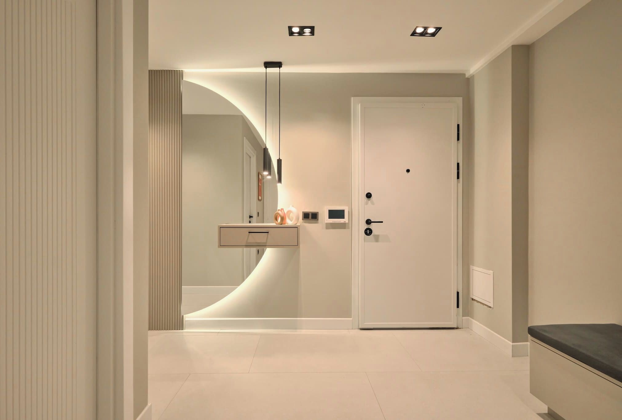 Een moderne badkamer met een gebogen wastafel, toilet en douche.