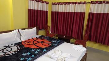 Habitación de hotel con una cama, un escritorio y una silla. Hay cortinas en las ventanas.