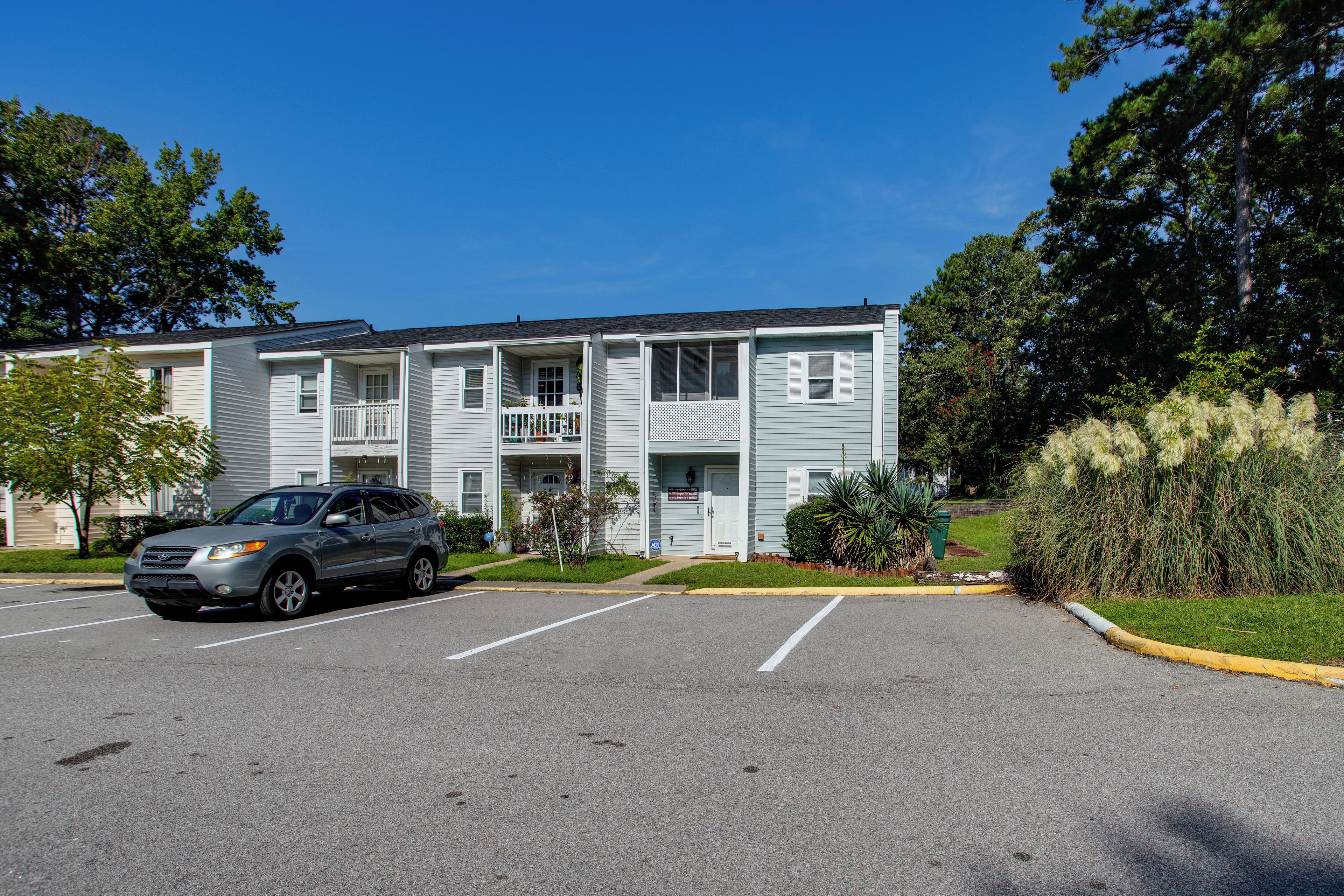 A multi-story building with a parking lot in front.