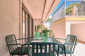 A covered outdoor dining area with a table and chairs, potted plants, and a view of the sky. - Arcturus, 2BR, Best Loc (Kadıköy)