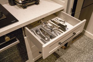 Eine Schublade mit Küchenutensilien und einer Kaffeemaschine.