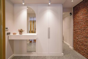 A hallway with a white wardrobe, a mirror, and a small table with a vase. - Renovated, Stylish, 3BR Kadıköy (Kadıköy)
