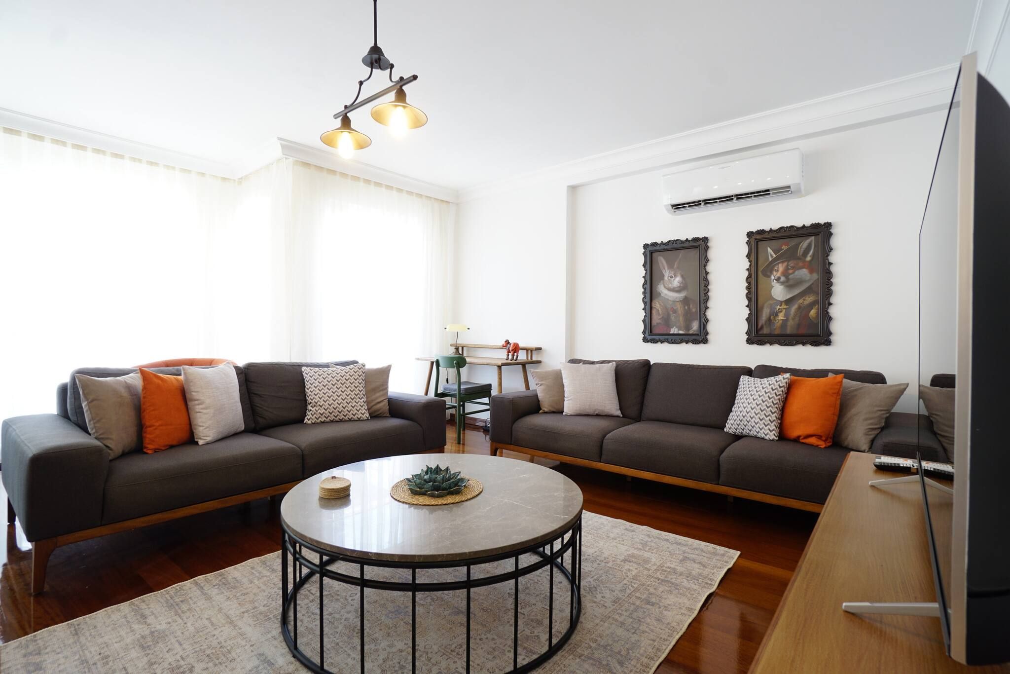 A living room with two sofas, a coffee table, and a wall-mounted TV.