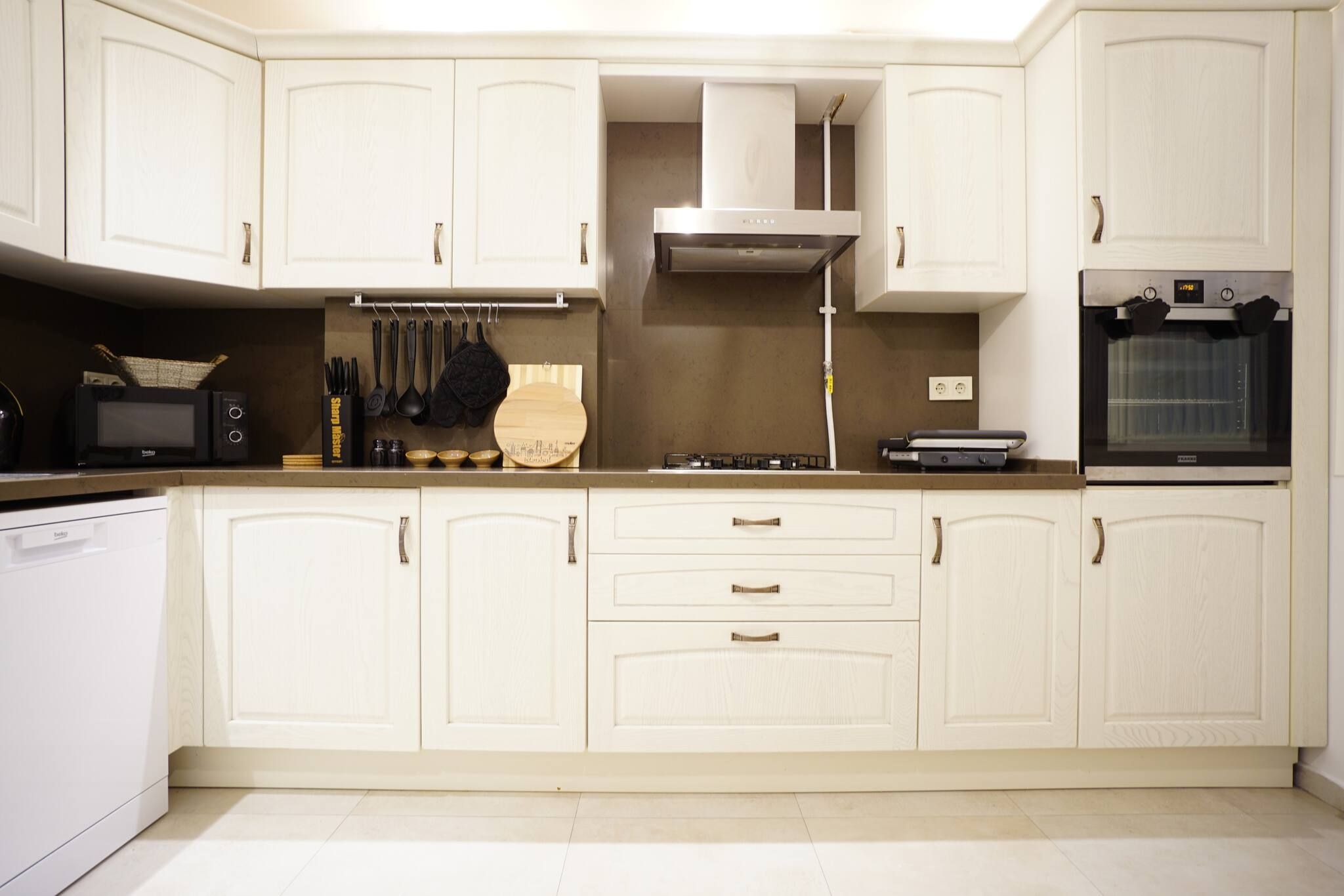 A kitchen with white cabinets, a microwave, a stove, and an oven.