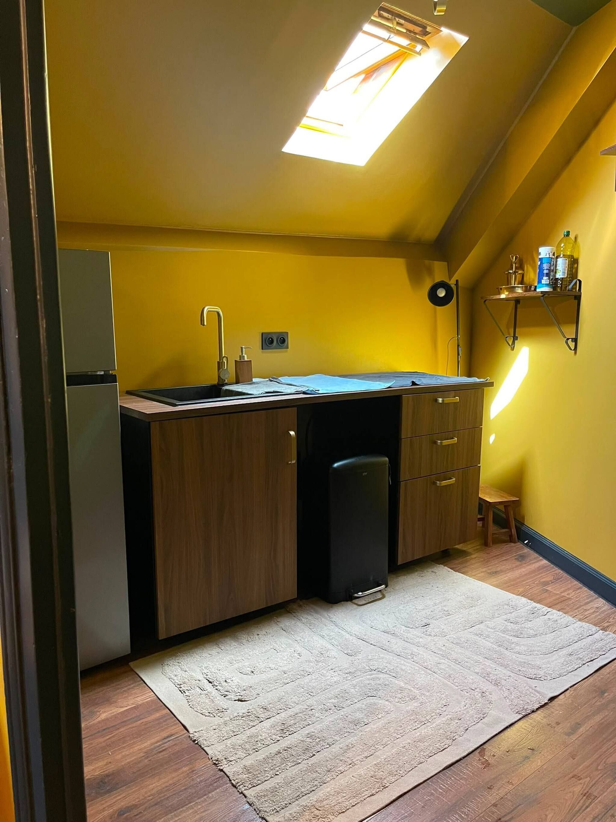 Cozinha compacta com geladeira embutida, pia e bancada.