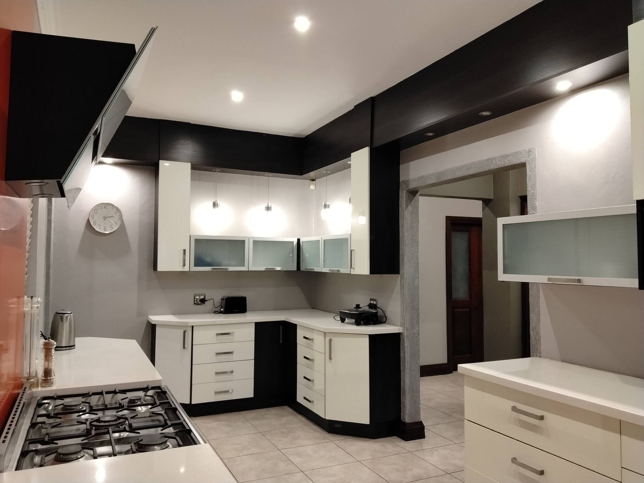 Una cocina moderna con armarios blancos, estufa a gas y microondas.