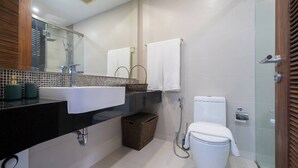 Een moderne badkamer met een zwart wastafel, een douchecabine met glazen wanden, en een wit toilet.