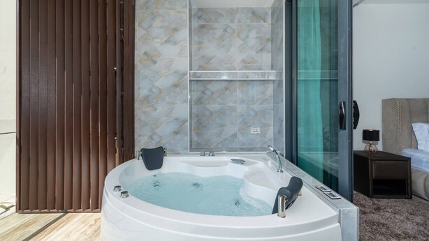 Een moderne badkamer met een vrijstaand bad, marmeren tegels en een douchecabine van glas.