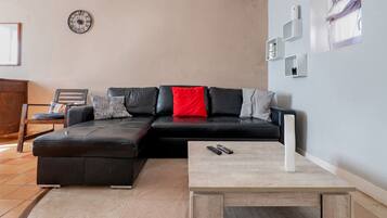 Una sala de estar moderna con un sofá modular, una mesa de centro y un reloj en la pared.