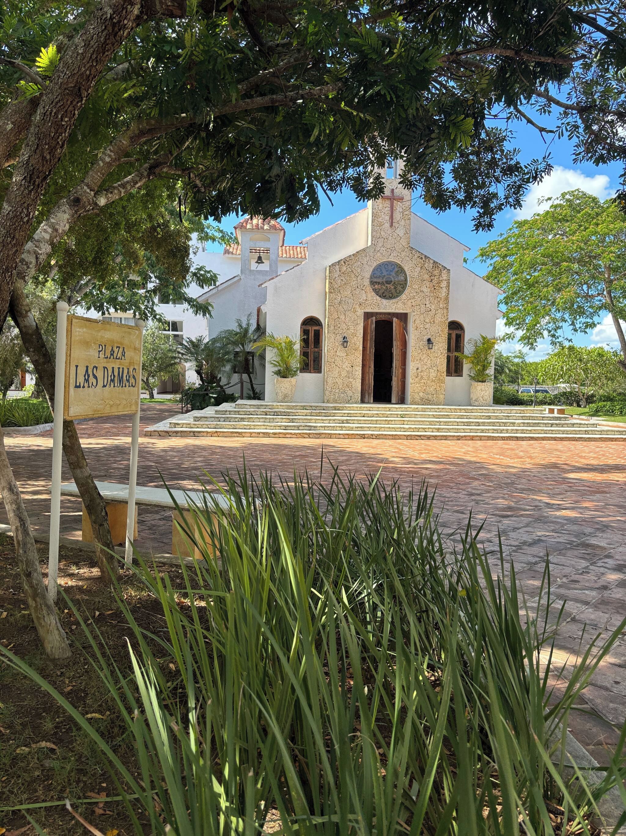 Una iglesia con un campanario y un cartel que dice 'Plaza Las Damas'.