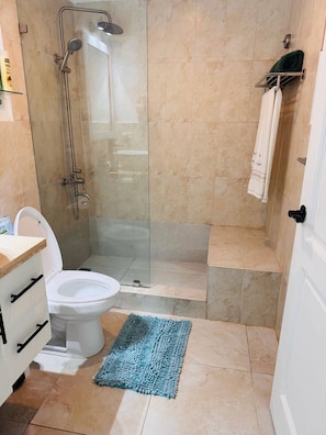 Ein Badezimmer mit Duschkabine, Toilette und Waschbecken.