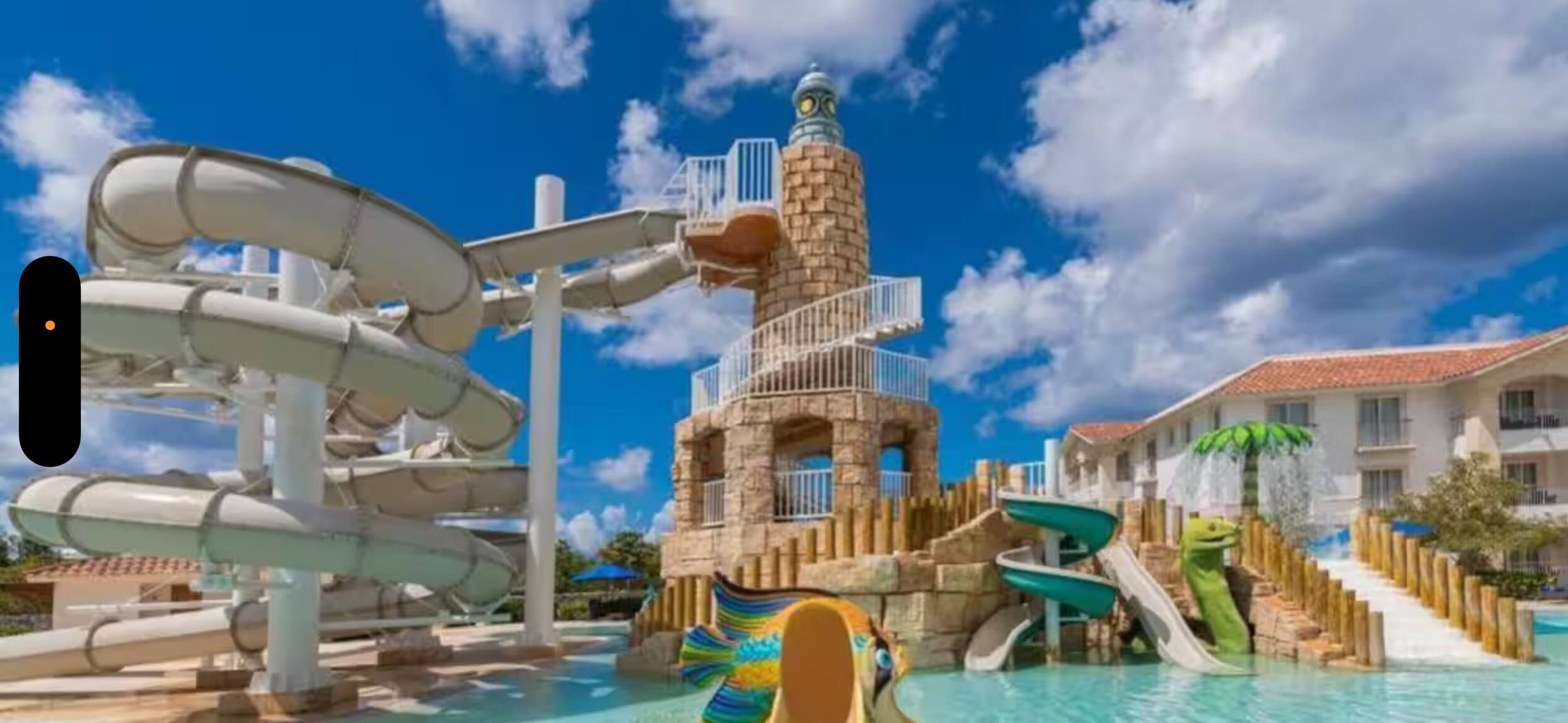 Parque acuático con un tobogán grande, una torre de agua y una piscina.