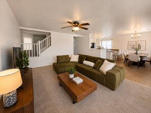 A modern living room with a sofa, coffee table, and a ceiling fan.