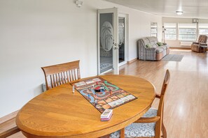A dining area with a round wooden table, chairs, and a board game. - Waterfront Escape w/ Private Dock! Okeechobee Lake (Okeechobee)