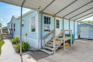 A light blue building with a covered porch, a staircase leading to the entrance, and a small shed in the background. - Waterfront Escape w/ Private Dock! Okeechobee Lake (Okeechobee)