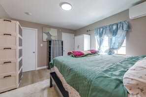 Ein Schlafzimmer mit Bett, Kleiderschrank und Deckenleuchte.