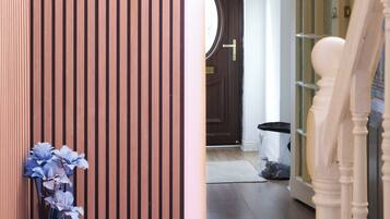 Een houten wandpaneel, een trap en een deur die leidt naar een kamer met een rond raam.