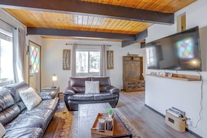 A living room with a leather sofa, a coffee table, a TV, and a wooden cabinet. - 1 Mi to Snow Play! 4-Season Big Bear Escape (Big Bear)