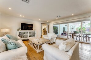 A spacious living room with white furniture, a wooden coffee table, and a television on the wall. - 2 Mi to Beach! Extended Getaway in Fort Lauderdale (Fort Lauderdale)