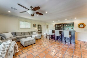 A living room with a sofa, ottoman, and a dining area with bar stools. - 2 Mi to Beach! Extended Getaway in Fort Lauderdale (Fort Lauderdale)