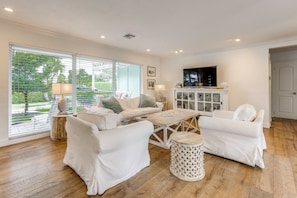 A living room with a sofa set, a coffee table, and a TV. There is a window with blinds, a lamp, and a cabinet with decorative items. - 2 Mi to Beach! Extended Getaway in Fort Lauderdale (Fort Lauderdale)