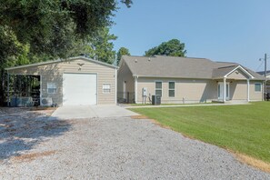 A two-story house with a garage, a covered porch, and a well-maintained lawn. - Lake Marion Retreat | Dock Days & Backyard Nights (Summerton)