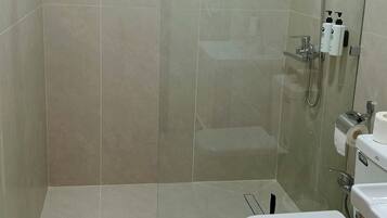 Un baño moderno con ducha envuelta en vidrio, inodoro y lavamanos.