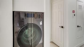 A wall-mounted washing machine with a control panel and a door with a sign indicating a 20-year warranty.