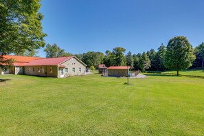 A residential property with a large lawn, a main house, and a smaller building, possibly a garage or shed, under a clear sky. - On-Site Ponds! Peaceful Franklin Studio (Franklin)
