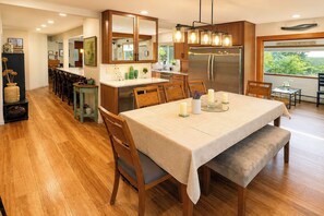 A modern kitchen with a central island, wooden cabinets, and a stainless steel refrigerator. - Ketchikan Oceanfront Retreat | Dock On-Site, Beach (Ketchikan)