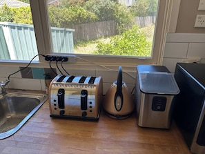 A kitchen with a window, a sink, a toaster, a kettle, and a blender. - Locum Welcome Home - Close to Canberra Hospital (Garran)
