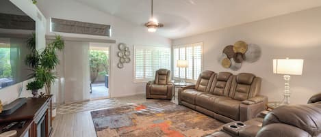 A modern living room with a leather sofa, a coffee table, and a fireplace.