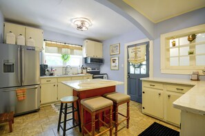 A kitchen with a central island, bar stools, a refrigerator, and a microwave. - Wine Country Retreat! Sun Porch, Private Yard (Lexington)