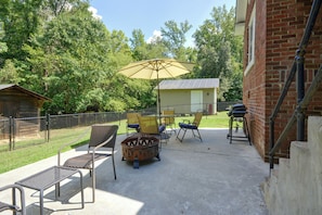 An outdoor patio area with metal furniture, a fire pit, and a large umbrella. - Wine Country Retreat! Sun Porch, Private Yard (Lexington)