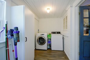 A laundry room with a washing machine, dryer, and cleaning supplies. - Wine Country Retreat! Sun Porch, Private Yard (Lexington)