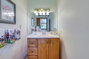 A bathroom with a wooden vanity, a large mirror, and a window. - Ride, Ski & Explore: Franklin, Vermont Getaway (Franklin)