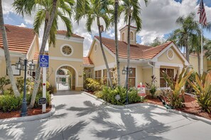 A building with a red-tiled roof, a wheelchair-accessible parking sign, and a private property sign. - Venetian Palms Condo: Pool, Hot Tub & Tennis! (Fort Myers)