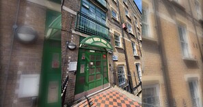 A building with a green door, a checkered pavement, and a sign that reads 'Devon Mansions.' - Timeless Retreat 5 Minutes from Tower Bridge (Greater London)