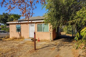 A single-story house with a front door, two windows, and a small porch area. - Bakersfield Home w/ Workspace, Near Hospitals (Bakersfield)